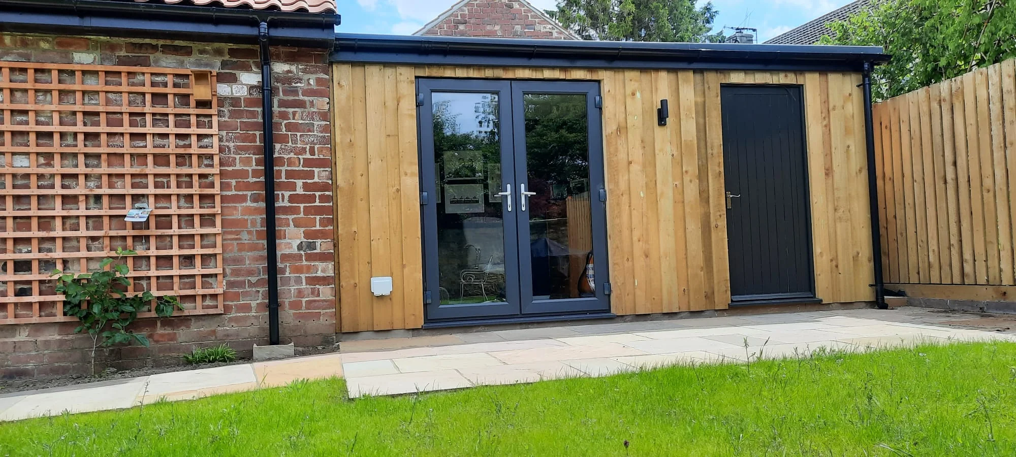 Timber-clad garden room with glazed double doors, built by RGS Joinery and Building